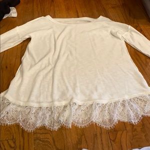 A white long sleeve shirt with lace at bottom